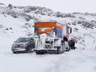 car rescued by a snowplow, Iceland mountain road in winter