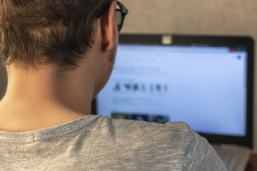 man with glasses working at a laptop at home. soft focus. home work concept