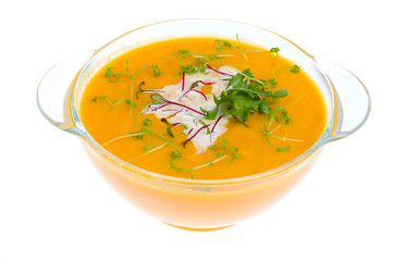 Vegetable cream soup with young green sprouts isolated on white background.