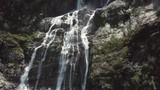 Close-up raging mountain waterfalls. Aerial view of giant waterfall flowing in mountains. Beautiful landscape