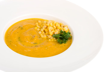 White plate with corn mash soup