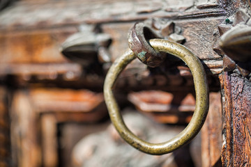Side view image of an old door knocker attached to a wooden door