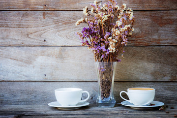 Coffee cup and vase on table.