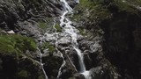 Close-up raging mountain waterfalls. Aerial view of giant waterfall flowing in mountains