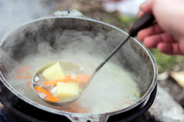 cook soup on fire in a cauldron. In a hike