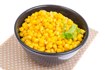 Canned corn in black bowl.