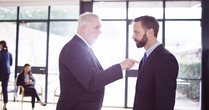 4K Mature businessman being aggressive & confrontational with younger colleague