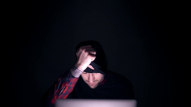 Sexy man in a balaclava takes off his mask and looks into the camera. Man terrorist removes the mask. 