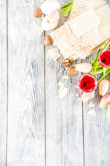 Pesah celebration concept. jewish Passover holiday background with matzo, eggs, spring flowers, wine, green background copy space top view