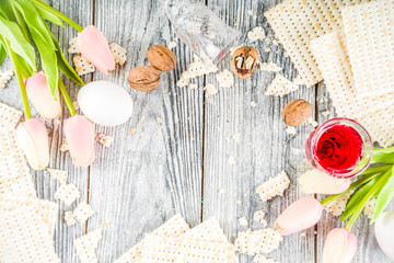 Pesah celebration concept. jewish Passover holiday background with matzo, eggs, spring flowers, wine, green background copy space top view
