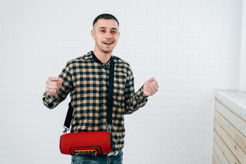 a young guy with a portable sound system for music working via Bluetooth
