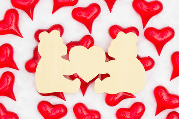 Wood bears sign with red hearts on white fabric background