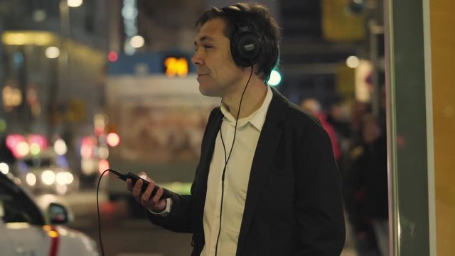 hombre mirando m&oacute;vil en la calle de noche ciudad