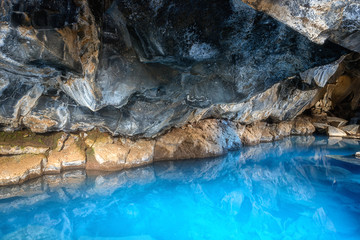 Grjotagja cave in Iceland with thermal spring hot amazing blue water, small lava cave near lake Myvatn