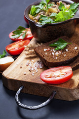 Homemade fried potatoes with mushrooms, rye bread, vegetables and spices