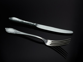 Cupronickel knife and fork on a black background