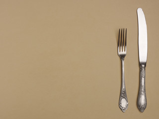 Cupronickel fork and knife on a yellow background with copyspace