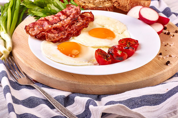 fried eggs with cherry tomatoes on the grill with bread