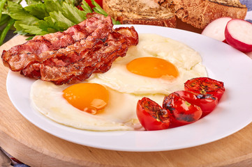 fried eggs with cherry tomatoes on the grill with bread