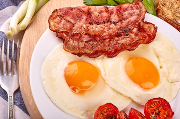 fried eggs with cherry tomatoes on the grill with bread