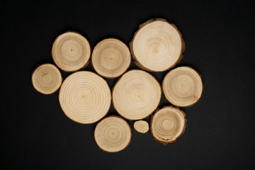 Pine tree cross-sections with annual rings on black background. Lumber piece close-up shot, top view.