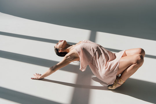 Ballerina in pink dress dancing in sunlight