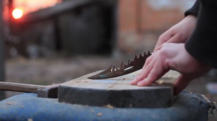 male hands with a knife make notches on the board