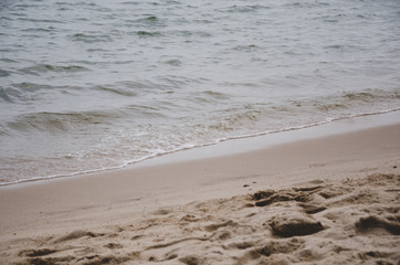 The sea waves swept onto the sand at the beach.