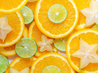 Citrus fruits slices background. Abstract backdrop with slices of lime, orange and carambola stars....