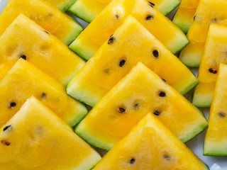 Tropical background. Yellow watermelon triangles, top view, closeup