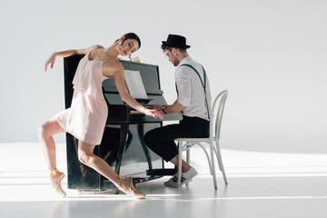 young musician playing piano while graceful ballerina dancing near him © LIGHTFIELD STUDIOS