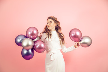 Fototapeta premium Young girl with balls on a colored background