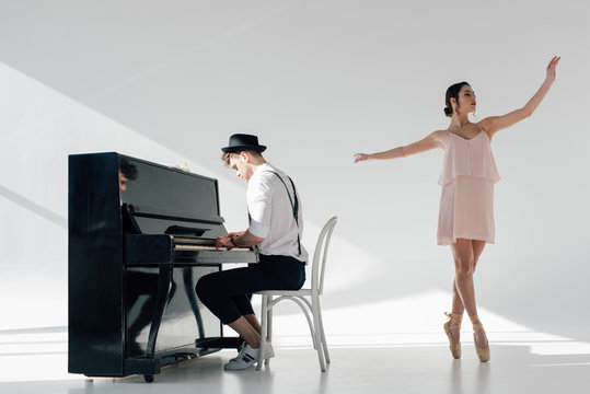 musician playing piano and dancing graceful ballerina