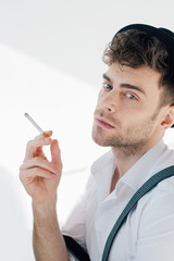 handsome man holding cigarette and looking at camera