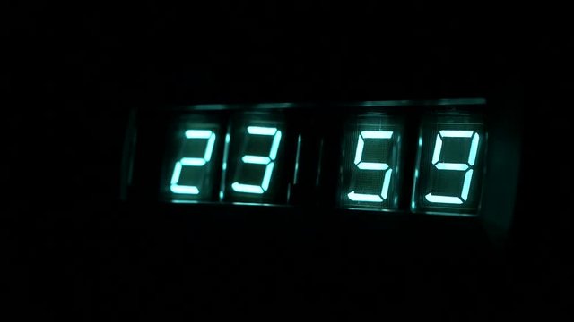 Lamp neon clock glow in the dark. watch time 23 ; 59 to 00 ; 00