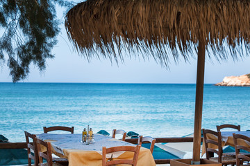 Table with sea view. Reed umbrella.