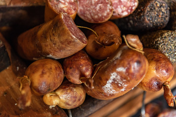 Variety of processed cold meat products with condiments. Assortment of different cold meats in a basket