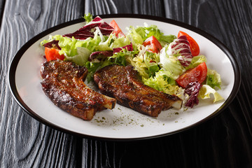 Freshly made lamb chops with fresh vegetable salad close-up on a plate. horizontal