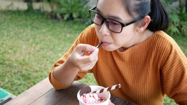 Closeup portrait with Asian young woman with hypersensitive teeth eating ice cream. Health and tooth Problem concept.
