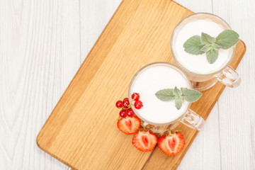 Delicious strawberry yogurt with mint leaves in glasses.