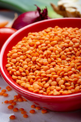 Dried orange lentils legume in red bowl