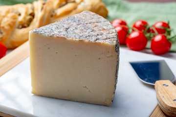 Italian cheese, piece of mature Tuscan Pecorino sheep cheese served with olive bread and tomatoes