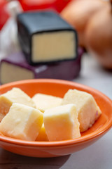 Mini black and dark red waxed cheddar cheeses with strong flavor made from West Country milk and and age-old methods with onion and garlic in England