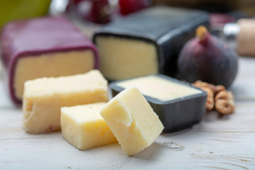 Mini black and dark red waxed cheddar cheeses made from West Country milk and and age-old methods in England