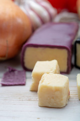 Mini black and dark red waxed cheddar cheeses with strong flavor made from West Country milk and and age-old methods with onion and garlic in England