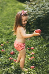 Girl with apples on the green grass