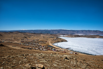 View of spring landscape in Siberia with part of frozen lake Baikal in the distance from the top view.