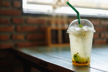 Fresh passion fruit juice and haft passion fruit on top with wooden table background. Hipster style.