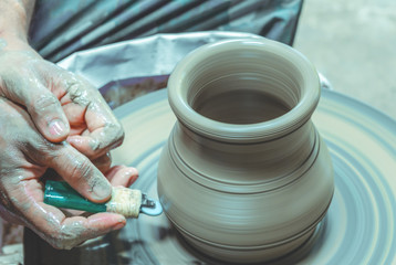 Potter make a clay bowl on a potter wheel at Koh Kret Pottery Village and Brewery, Pak Kret District, Nonthaburi,Thailand.