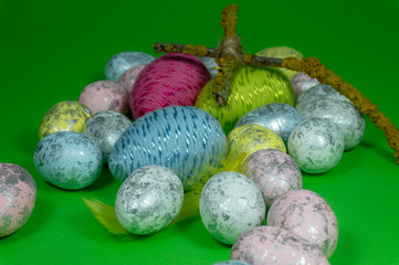 Handmade Easter eggs and cross of twigs on green